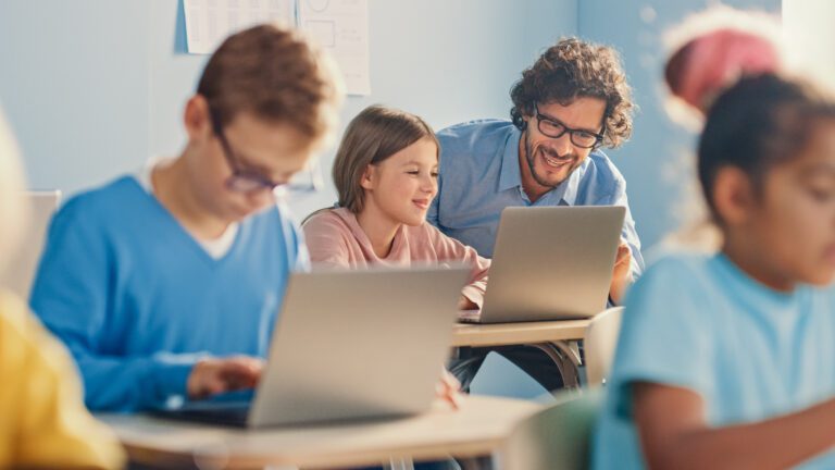 Girl Using Laptop Among Peers