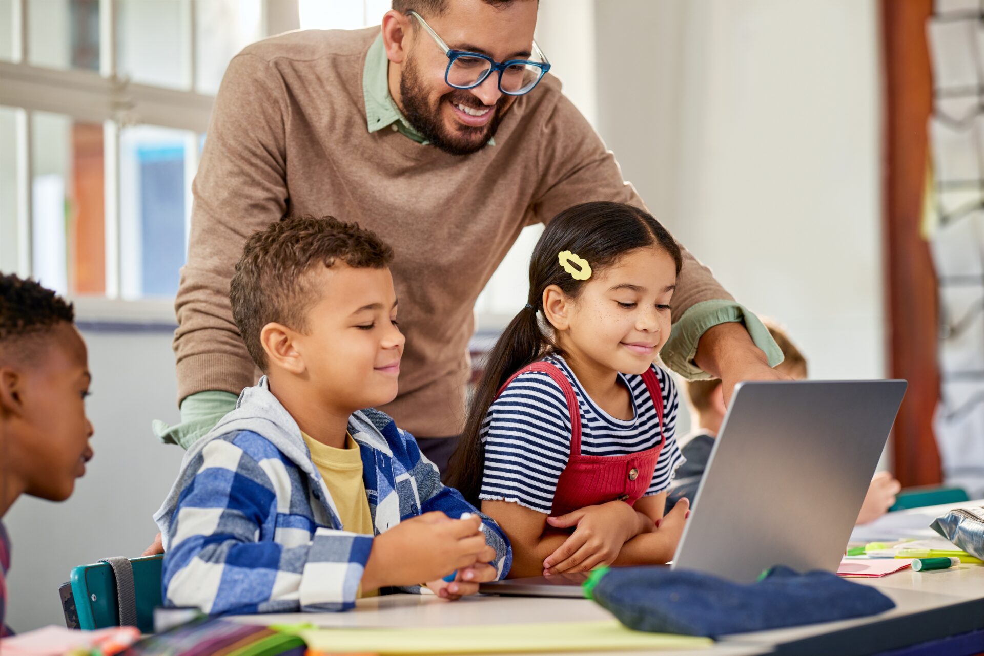 ES Teacher Working with Students on Laptop