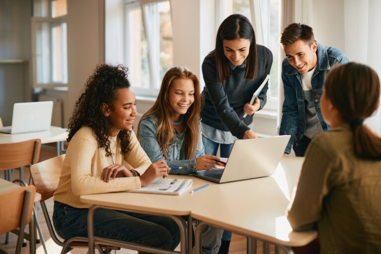 Teacher with Multiple HS Students and Laptop